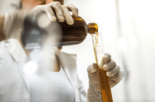 a natural skincare formulator measuring oil to make clean natural beauty products