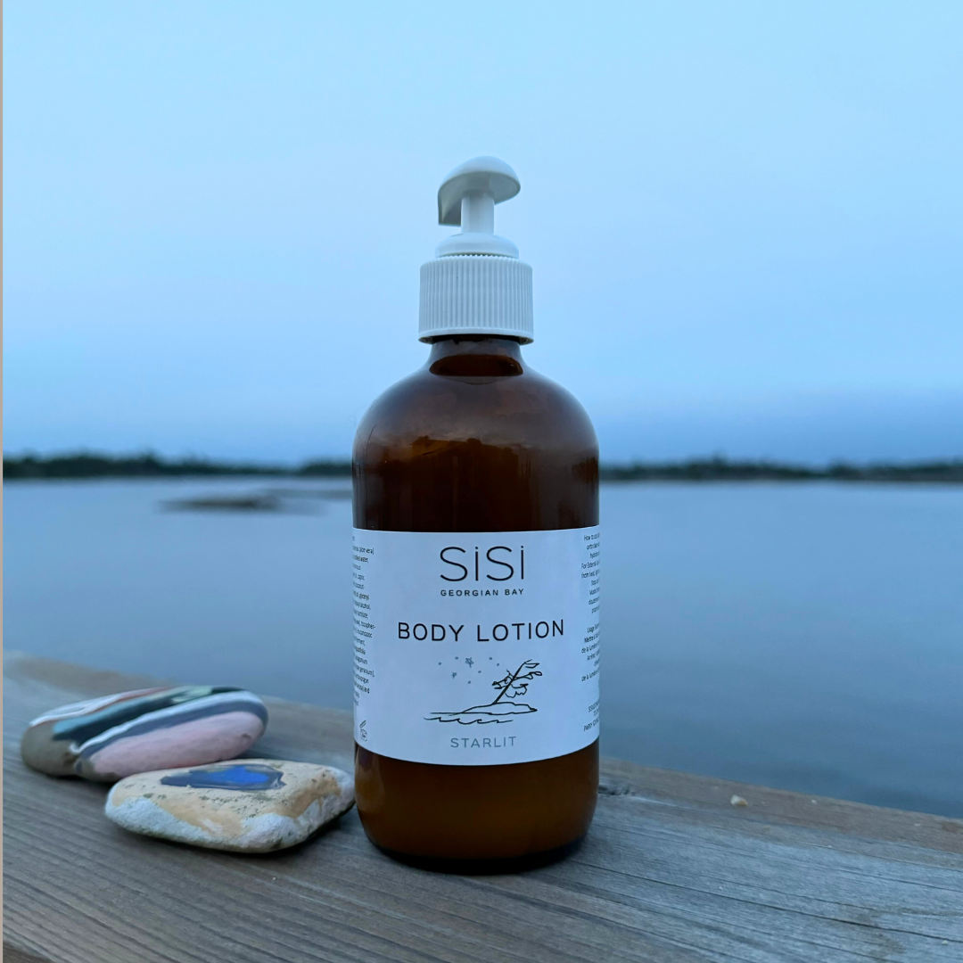 Bottle of SISI body lotion on a wooden dock with a scenic background