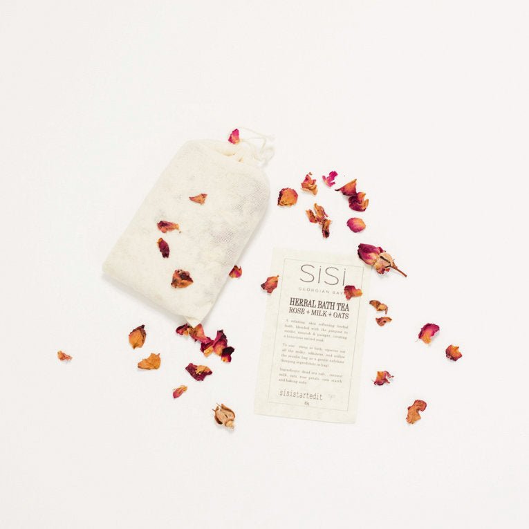 a pretty styled photo of a sisi georgian bay herbal bath tea in a muslin bag on a creamy background with Rose petals sprinkled around