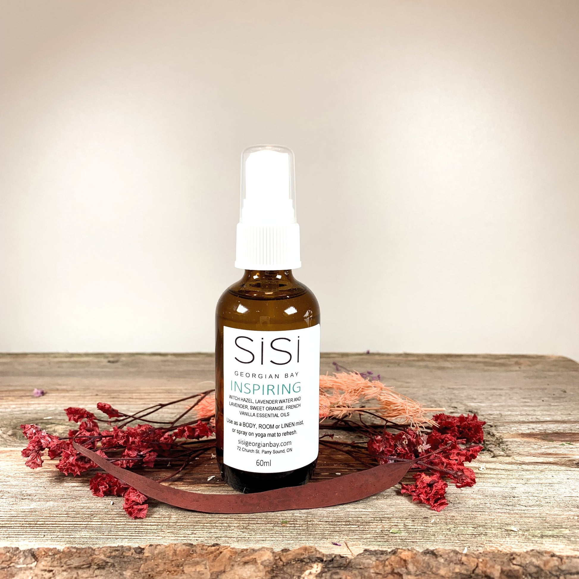 Aromatherapy Products - SiSi Georgian Bay Yoga Sprays in amber glass bottles on a rustic wooden live edge surface with flowers spread around the bottom
