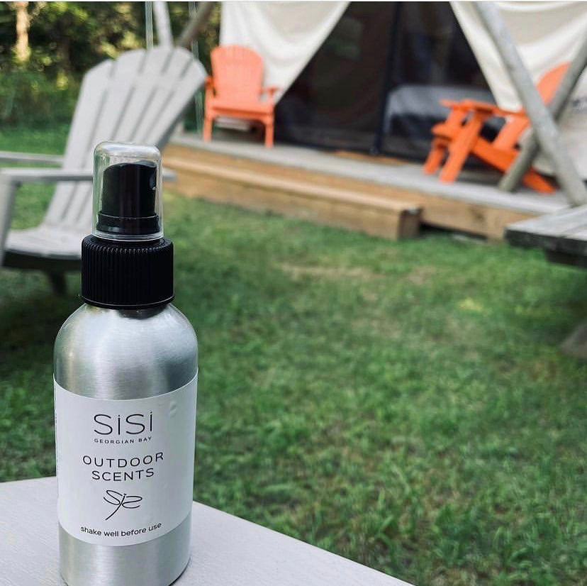 Aromatherapy Products - SiSi Georgian Bay natural skincare products Outdoor Scents in an aluminum bottle with a spray top lid on a table at a campsite wit a tent in the background and orange muskoka chairs