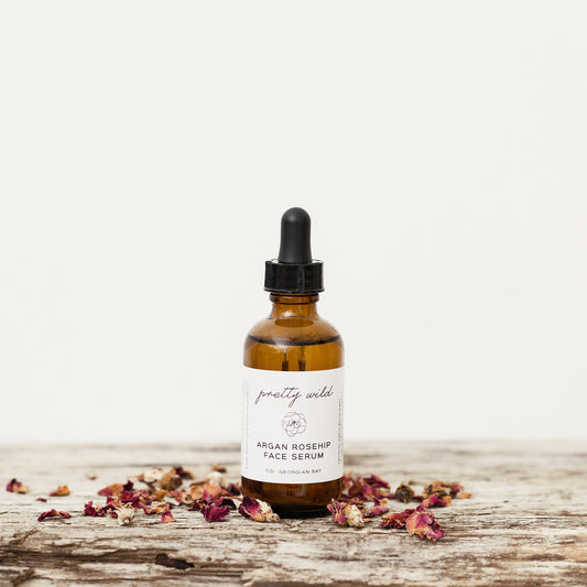 Natural skincare products in northern Ontario A beautiful eco friendly amber glass bottle with a glass dropper applicator, complimented by a beautiful pretty wild lavel on a rustic piece of wood with a sprinkling of rose petals.
