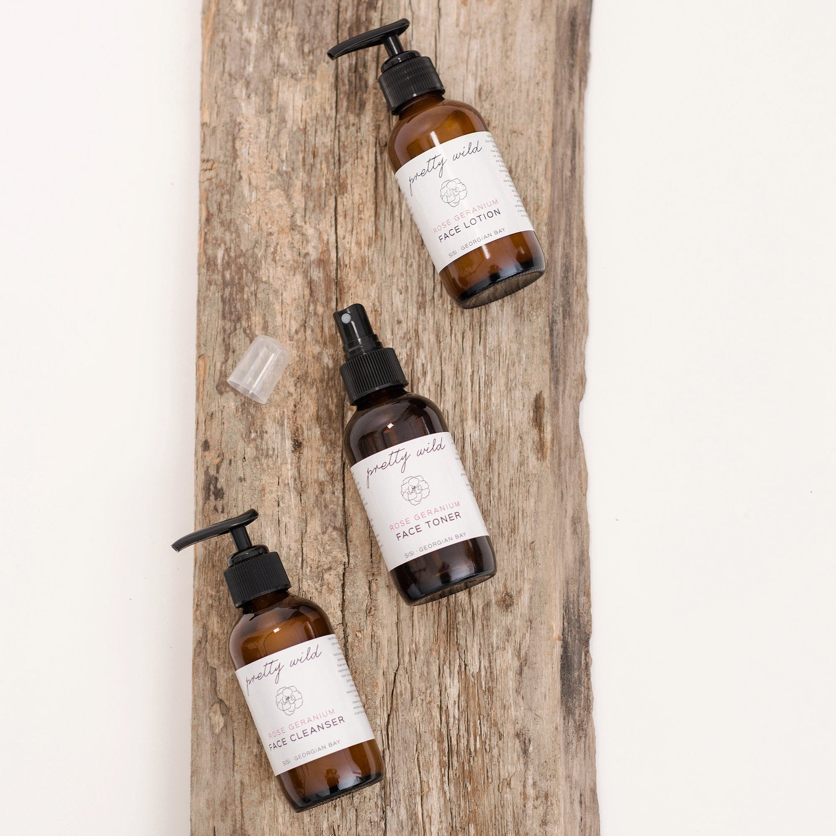 Natural beauty care products - SiSi Georgian Bay "pretty wild" face care essentials - cleanser, toner and lotion on a rustic wooden board on a creamy white background